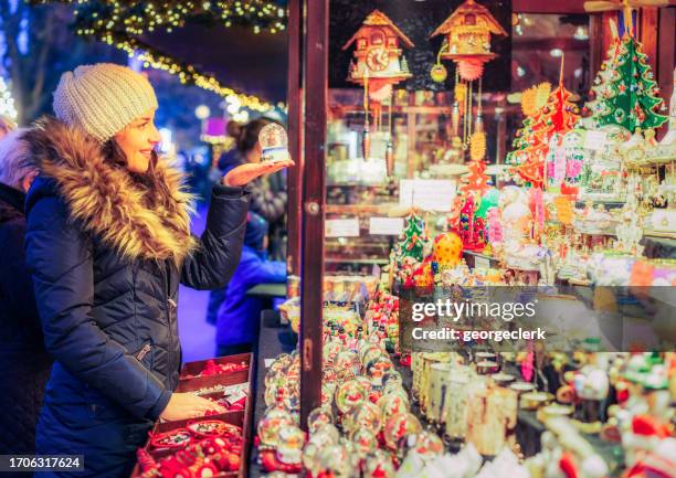 choosing a gift at winter markets - woman picking up toys stock pictures, royalty-free photos & images