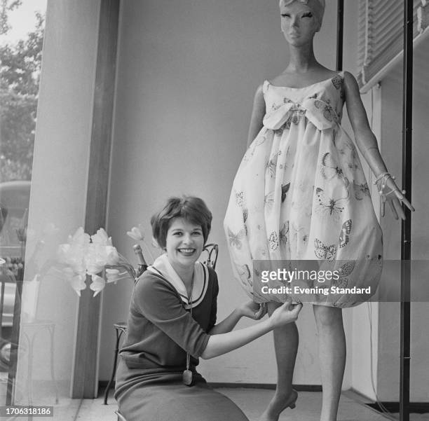 Shop assistant Susanna Leggatt adjusts the hem of a mannequin's dress at the Mary Quant shop 'Bazaar' boutique at 138a King's Road in Chelsea,...