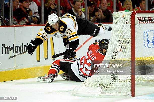 Torey Krug of the Boston Bruins falls to the ice over Brandon Bollig of the Chicago Blackhawks in Game Two of the NHL 2013 Stanley Cup Final at...