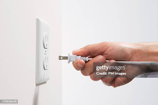 man about to plug in - electrical plug foto e immagini stock