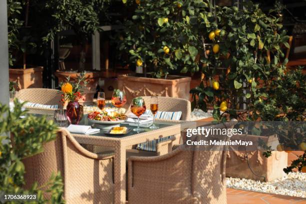 garden party outdoor table with food and drinks appetizer antipasti plate for hosting guests on mediterranean terrace patio - outdoor dining stock pictures, royalty-free photos & images
