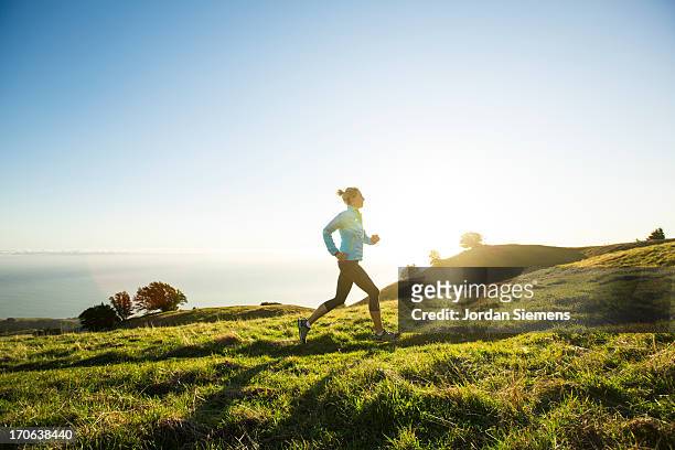 a female jogging for exercise. - jogging stock pictures, royalty-free photos & images