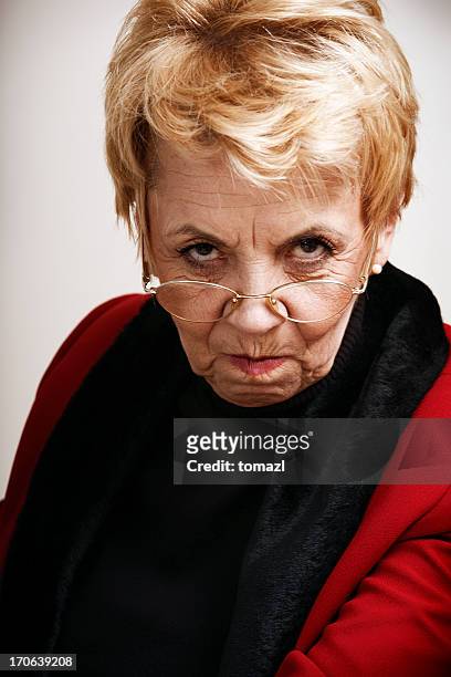 frowning senior woman - cruel stock pictures, royalty-free photos & images