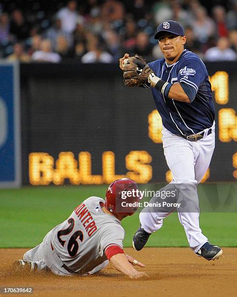 Everth Cabrera of the San Diego Padres can't turn a double play after getting the force out on Miguel Montero of the Arizona Diamondbacks during the...