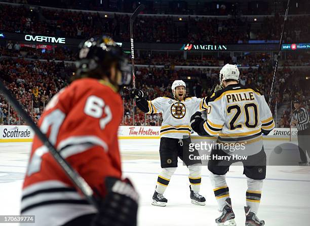 Daniel Paille and Andrew Ference of the Boston Bruins celebrate after Paille scored the game-winning goal in the first overtime against Michael...