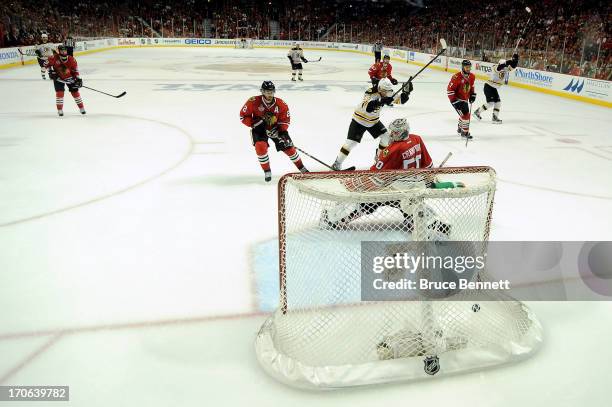 Goalie Corey Crawford of the Chicago Blackhawks lets in the game-winning goal in the first overtime off of the stick of Daniel Paille of the Boston...