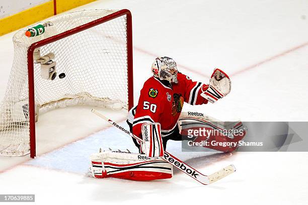 Goalie Corey Crawford of the Chicago Blackhawks lets in the game-winning goal in the first overtime off of the stick of Daniel Paille of the Boston...