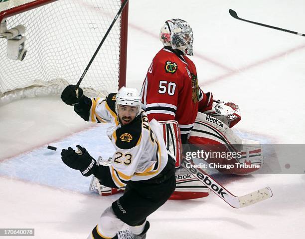 The Boston Bruins' Chris Kelly celebrates as Chicago Blackhawks goalie Corey Crawford allows the game-winning goal to Boston's Daniel Paille in...