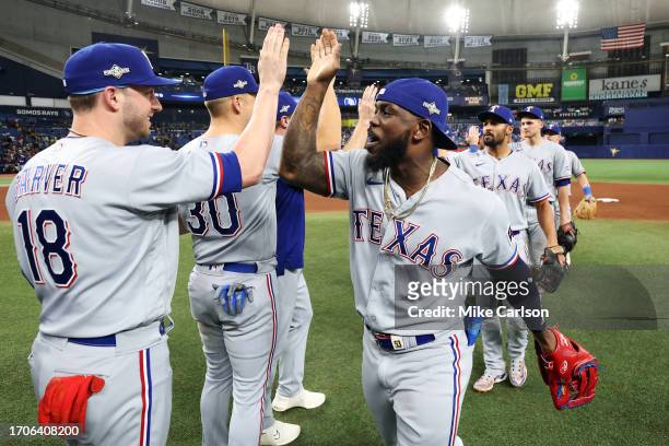 Mitch Garver and Adolis Garcia of the Texas Rangers celebrate with teammates after defeating the Tampa Bay Rays 7-1 in Game 2 of the Wild Card Series...