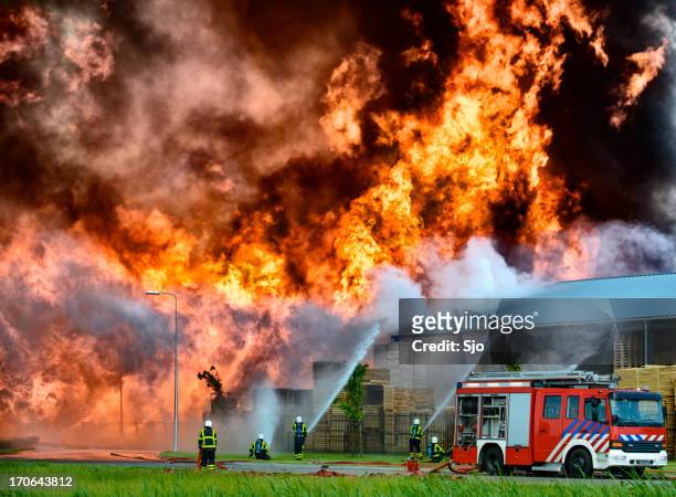 fire fighting in an industrial area - burning stockfoto's en -beelden