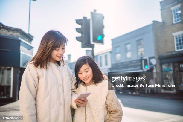 mom & daughter getting direction on smartphone while exploring in a town - road signal stock pictures, royalty-free photos & images