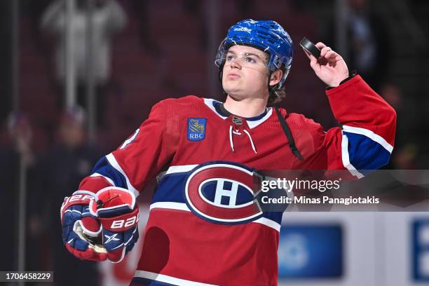 Cole Caufield of the Montreal Canadiens holds up a puck after a victory against the Ottawa Senators at the Bell Centre on September 27, 2023 in...