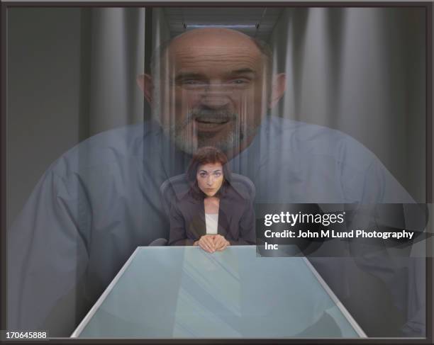 businessman superimposed over cowering businesswoman - interrogation stock-fotos und bilder