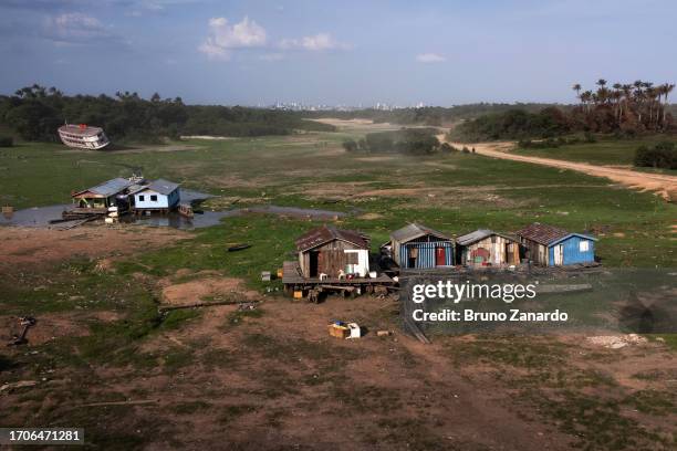 Aerial view of floating houses in a drought-hit harbor of Cacau Pirêra's dry in Amazonas on October 04, 2023 in Iranduba, Amazonas, Brazil. The state...