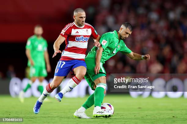 Guido Rodriguez of Real Betis battles for possession with Shon Weissman of Granada during the LaLiga EA Sports match between Granada CF and Real...
