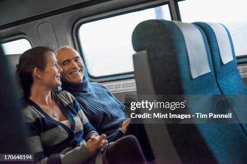 Taking Train Two People Sitting In A Railway Carriage Smiling Taking A Train Journey ...