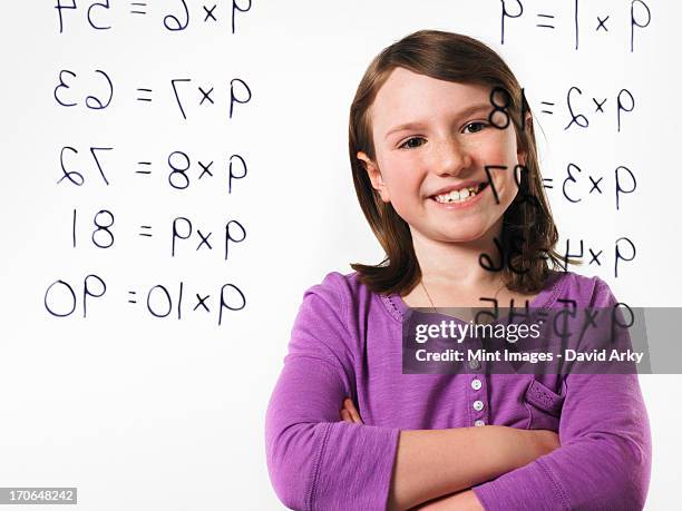 a child looking at a series of multiplication tables written on a see through surface. - moltiplicazione foto e immagini stock