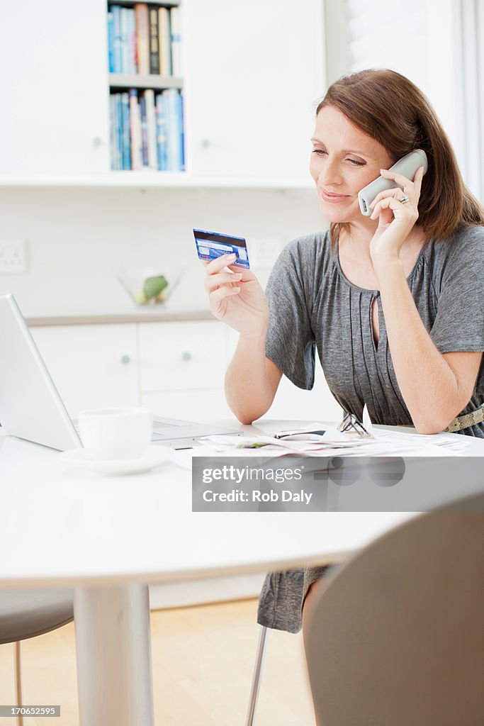Woman talking on telephone and holding credit card