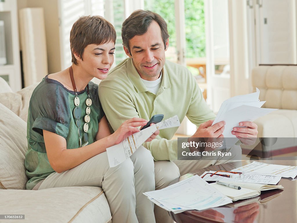 Couple on sofa paying bills