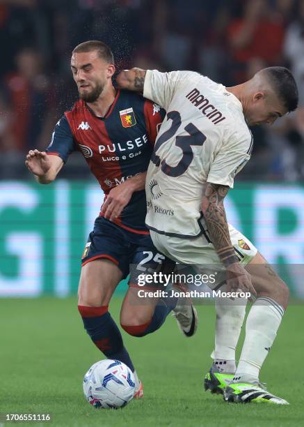 Berkan Kutlu of Genoa CFC receives an elbow to the face from Gianluca Mancini of AS Roma as they battle for the ball during the Serie A TIM match...