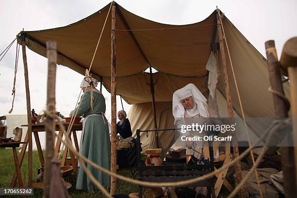 Re-enactors in period costume prepare food in a medieval encampment at Eltham Palace on June 16, 2013 in Eltham, England. The 'Grand Medieval Joust'...
