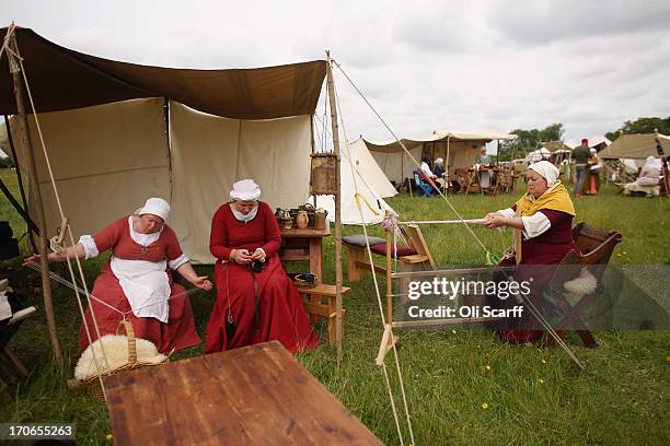 Re-enactors in period costume weave in a medieval encampment at Eltham Palace on June 16, 2013 in Eltham, England. The 'Grand Medieval Joust' event...