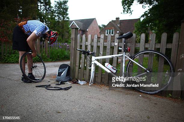 Cyclist repairs a puncture during the London to Brighton Bike Ride on June 16, 2013 in Smallfield, England. Every year since 1980, cyclists gather to...