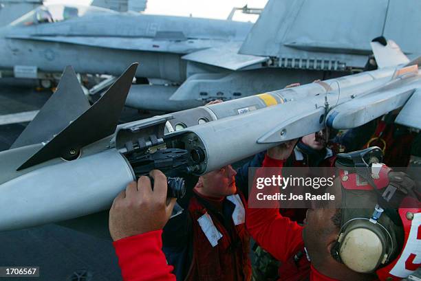 Navy sailor Lane McGann from Portland, Maine attaches a side winder missile to a fighter jet on the deck of the USS Constellation January 2, 2003 in...