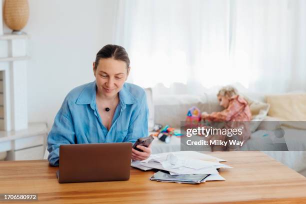 housewife looking through bills and documents from kids medical insurance online. - filing documents stock pictures, royalty-free photos & images