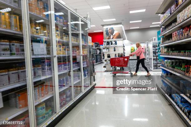 Products are locked behind glass as a person shops at a Target store in the Harlem neighborhood in Manhattan on September 28, 2023 in New York City....
