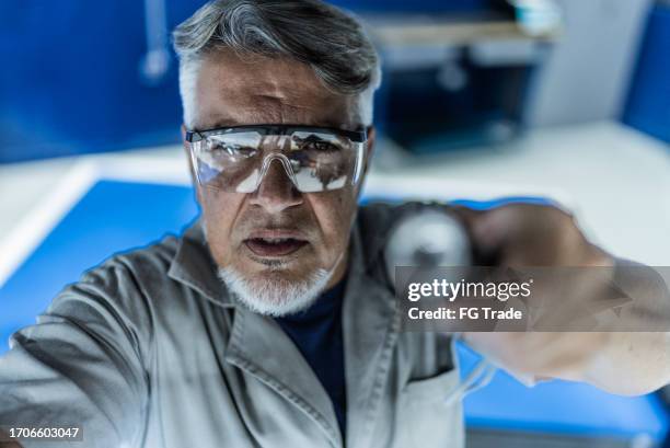 auto mechanic analyzing the car with a flashlight on a repair shop - camera point of view - camera point of view stock pictures, royalty-free photos & images