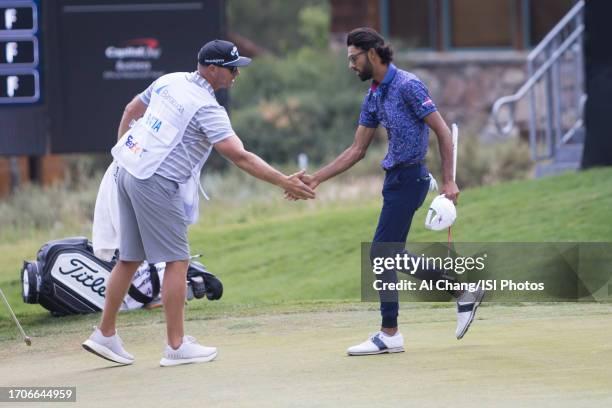 Akshay Bhatia of the United States shakes hands with his caddie after finishing on hole during the final round of the Barracuda Championship at Old...