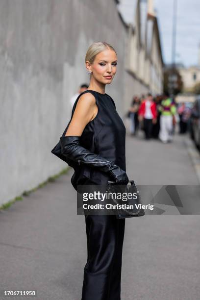 Leonie Hanne wears black satin dress, gloves, bag outside Givenchy during the Womenswear Spring/Summer 2024 as part of Paris Fashion Week on...