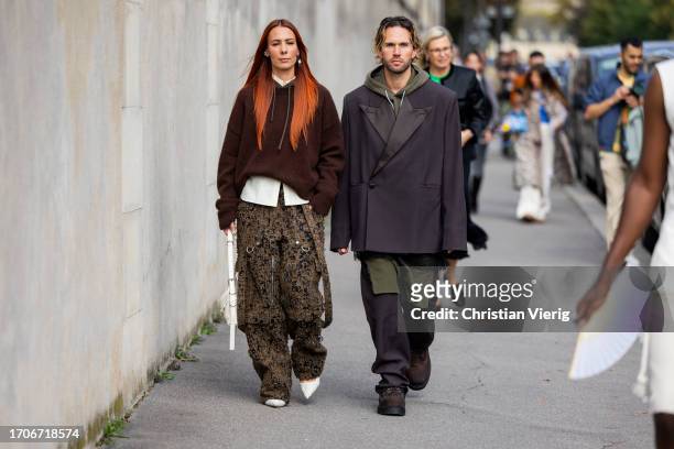 Couple Alice Barbier wears hoody, camouflage pants & Sebastian Roques wears oversized blazer outside Givenchy during the Womenswear Spring/Summer...