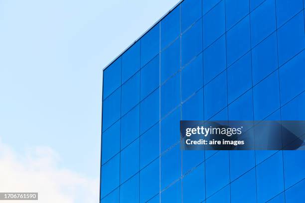 low angle view of the exterior of a blue glass building with the sky in the background - top that stock pictures, royalty-free photos & images