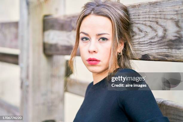 portrait of young woman wearing a black blouse and posing on some wooden fences at the san fermin festivities, pamplona, ​​spain - fiesta of san fermin stock pictures, royalty-free photos & images