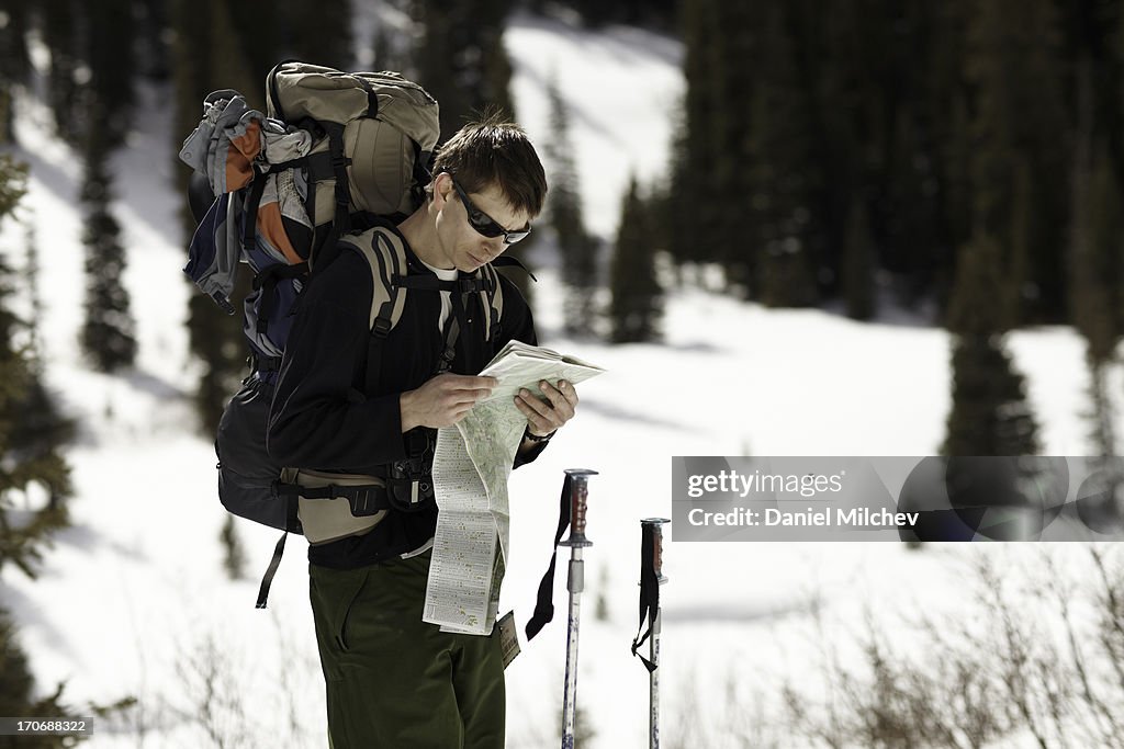 Guy looking at a map, on a backcountry ski trip.