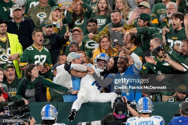 Amon-Ra St. Brown of the Detroit Lions celebrates with fans after scoring a touchdown against the Green Bay Packers during the first quarter in the...