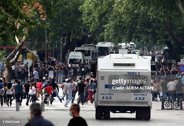 Protesters escape from a water cannon as they clash with police during an anti-government demonstration in Ankara on June 16, 2013. Turkish Prime...