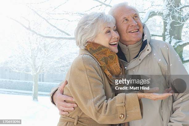 couple smiling in snow - two elderly men dressed in 70's outfits stock pictures, royalty-free photos & images