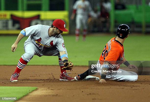 Justin Ruggiano of the Miami Marlins steals second base against shortstop Daniel Descalso of the St. Louis Cardinals during the first inning at...