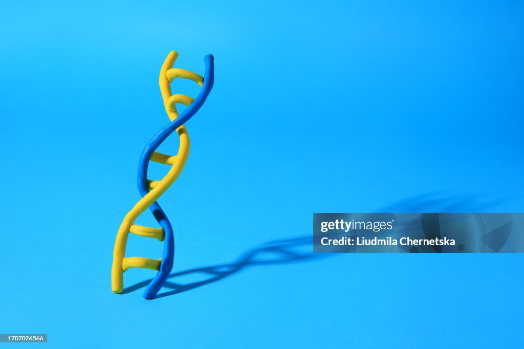 DNA molecule model made of colorful plasticine on light blue background, space for text