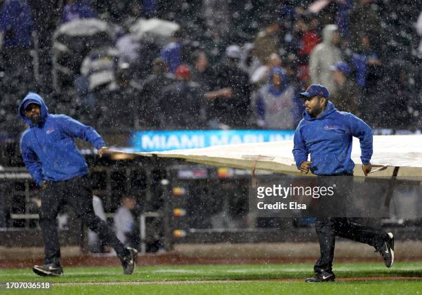 The New York Mets grounds crew covers the field during a rain delay in the top of the ninth inning during the game between the New York Mets and the...