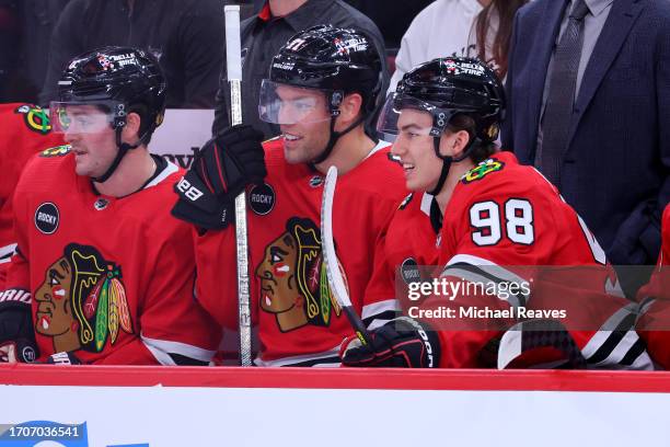 Taylor Hall and Connor Bedard of the Chicago Blackhawks laugh on the bench against the St. Louis Blues during the first period of a preseason game at...