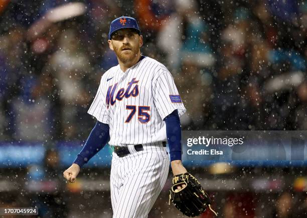 Reed Garrett of the New York Mets walks off the field as the tarp is pulled on the infield in the ninth inning against the Miami Marlins at Citi...