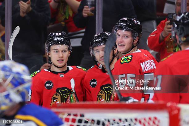 Philipp Kurashev of the Chicago Blackhawks celebrates with Connor Bedard and Kevin Korchinski after scoring a goal against the St. Louis Blues during...