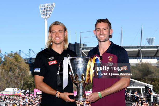 Darcy Moore of the Magpies and Harris Andrews of the Lions hold aloft the 2023 Premiership Cup during the 2023 AFL Grand Final Parade on September...