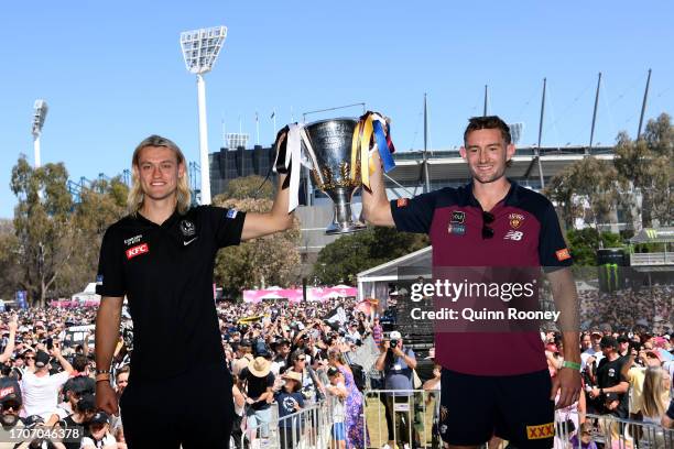 Darcy Moore of the Magpies and Harris Andrews of the Lions hold aloft the 2023 Premiership Cup during the 2023 AFL Grand Final Parade on September...