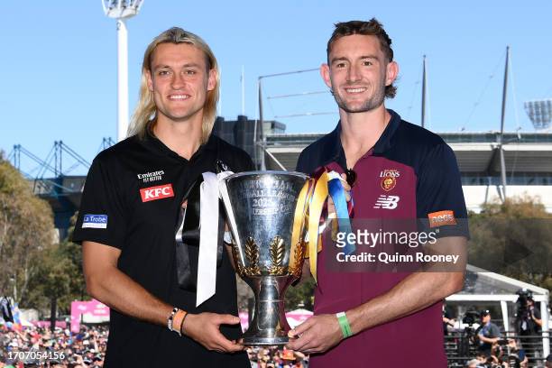 Darcy Moore of the Magpies and Harris Andrews of the Lions hold aloft the 2023 Premiership Cup during the 2023 AFL Grand Final Parade on September...