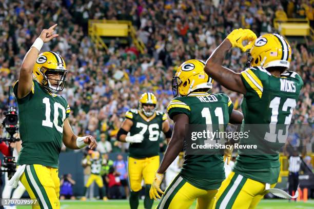 Jordan Love of the Green Bay Packers celebrates with Jayden Reed and Dontayvion Wicks after scoring a touchdown against the Detroit Lions during the...